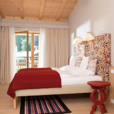 Ferienwohnung Werfenweng Ein Bett mit einem bunten Kopfteil in einem Raum.