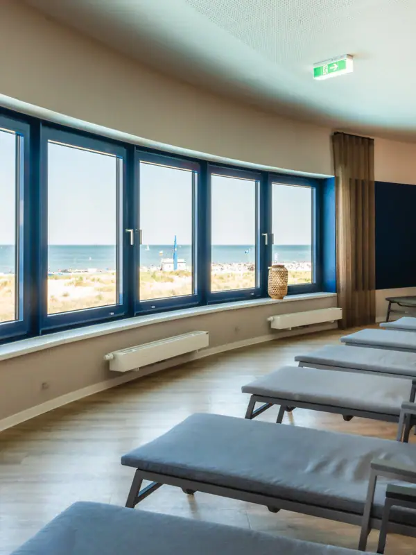 Ein Raum mit Stühlen und großen Fenstern.