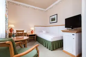 Ein Zimmer mit einem Bett und einem Fernseher.