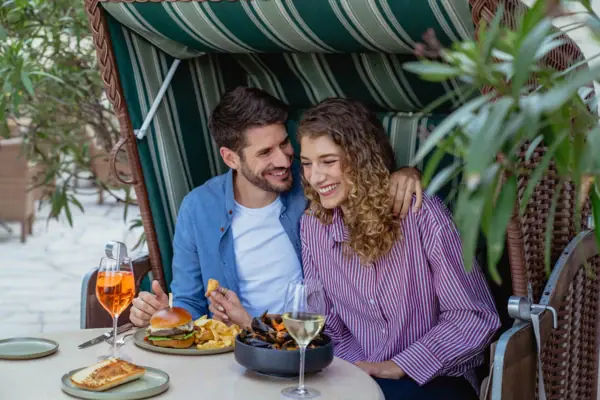 Ein Mann und eine Frau sitzen an einem Tisch mit Essen und Getränken.