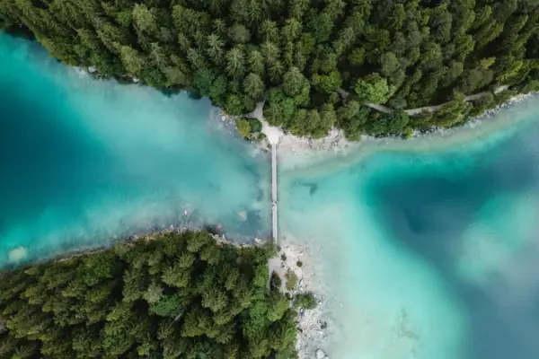 Eine Brücke über den Eibsee mit Bäumen.