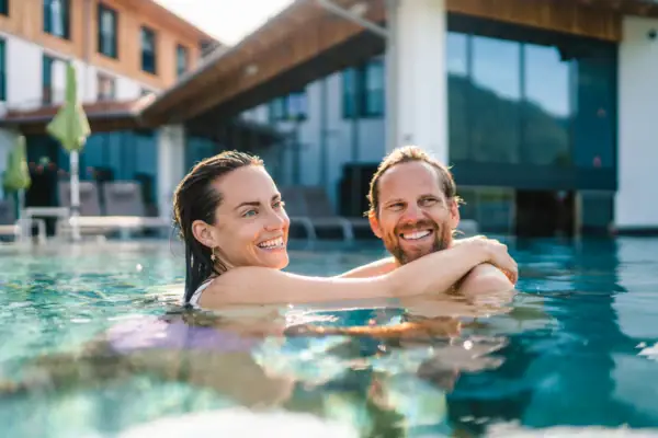 Pool Ein Mann und eine Frau in einem Schwimmbecken, beide lächelnd.