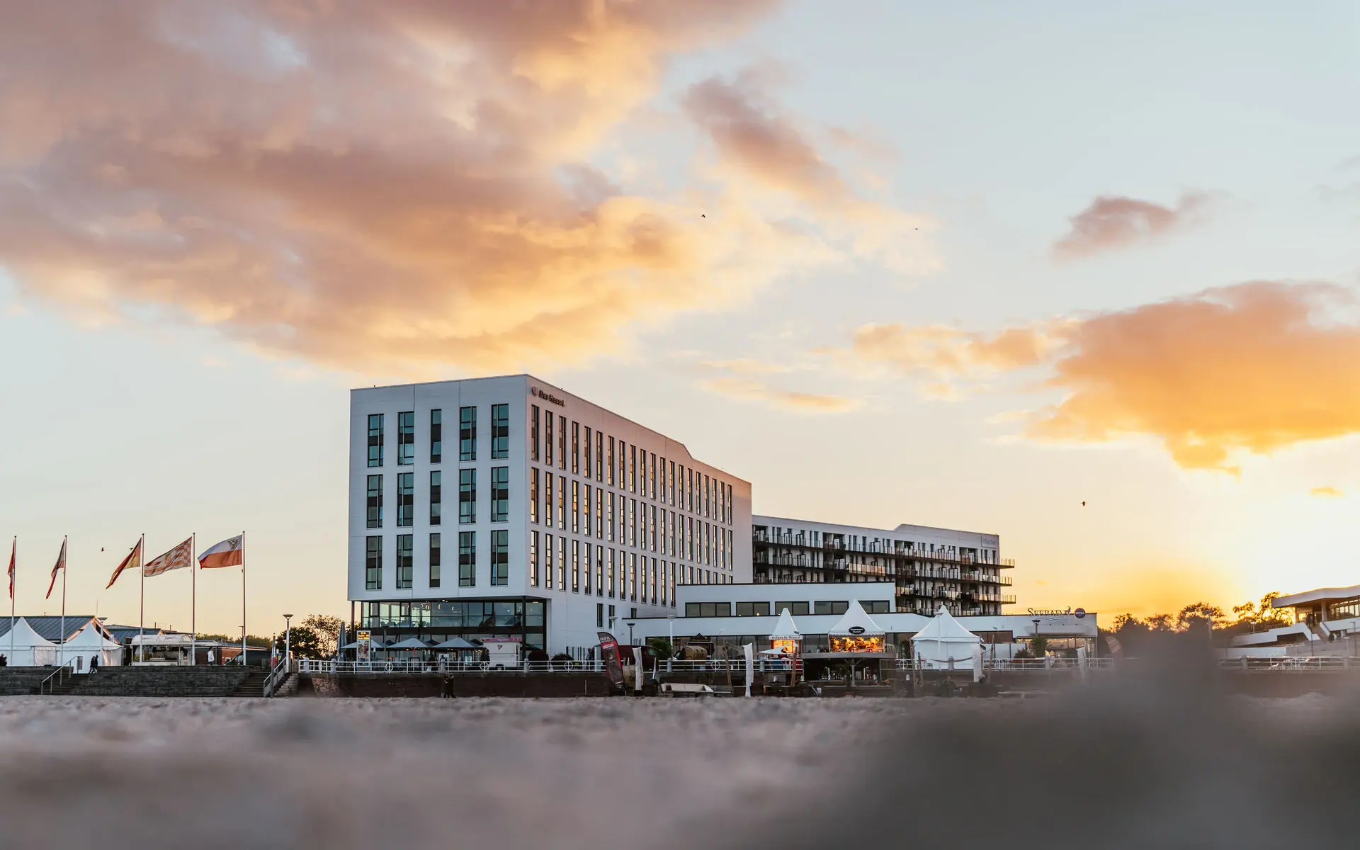 Ein Gebäude mit Flaggen davor bei Sonnenaufgang.