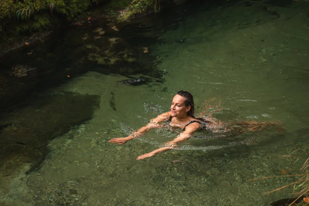 Frau schwimmt im Weißbach.