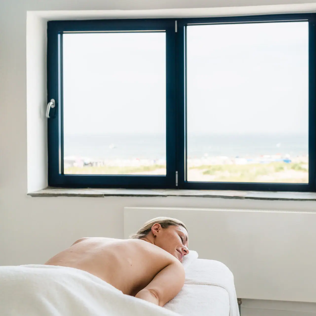 Anwendungsraum Eine Frau liegt auf einem Massagetisch.