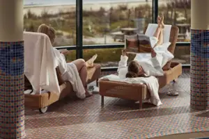 SPA Zwei Frauen in weißen Bademänteln liegen auf Stühlen.
