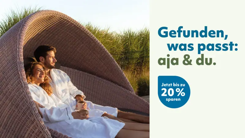 Ein Paar im Bademantel liegt in einem Korbsessel