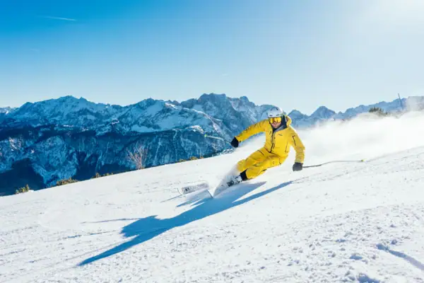 Eine Person fährt auf Skiern einen schneebedeckten Berg hinunter.