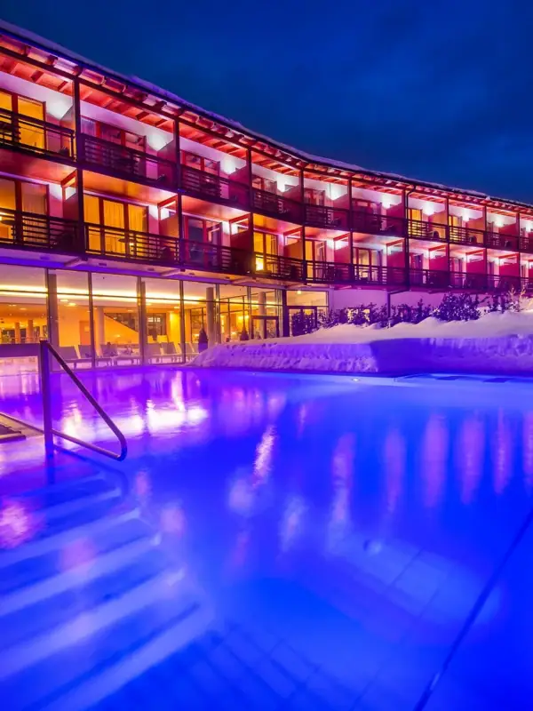 Ein Gebäude mit einem Pool und Schnee im Vordergrund.