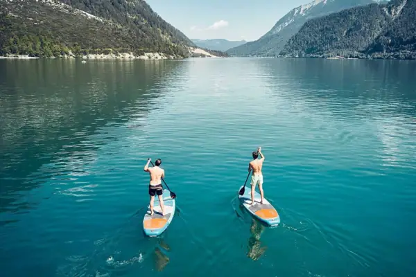 Zwei Männer auf Paddleboards auf einem See.