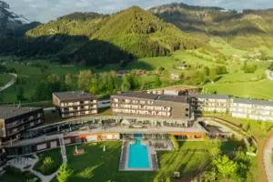 Hotel mit Pool inmitten eines grünen Feldes