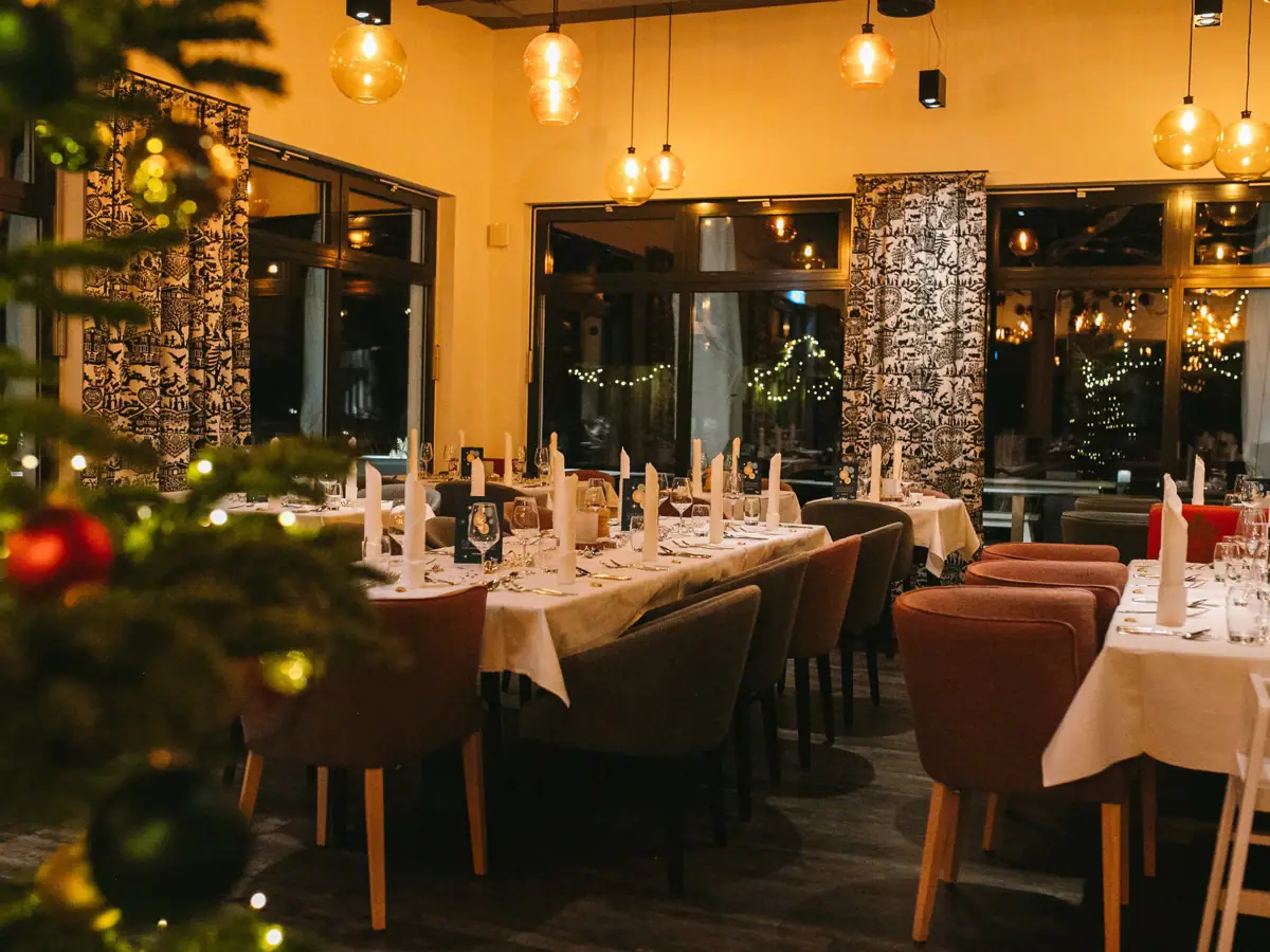 Ein Raum mit Tischen und Stühlen und einem Weihnachtsbaum.