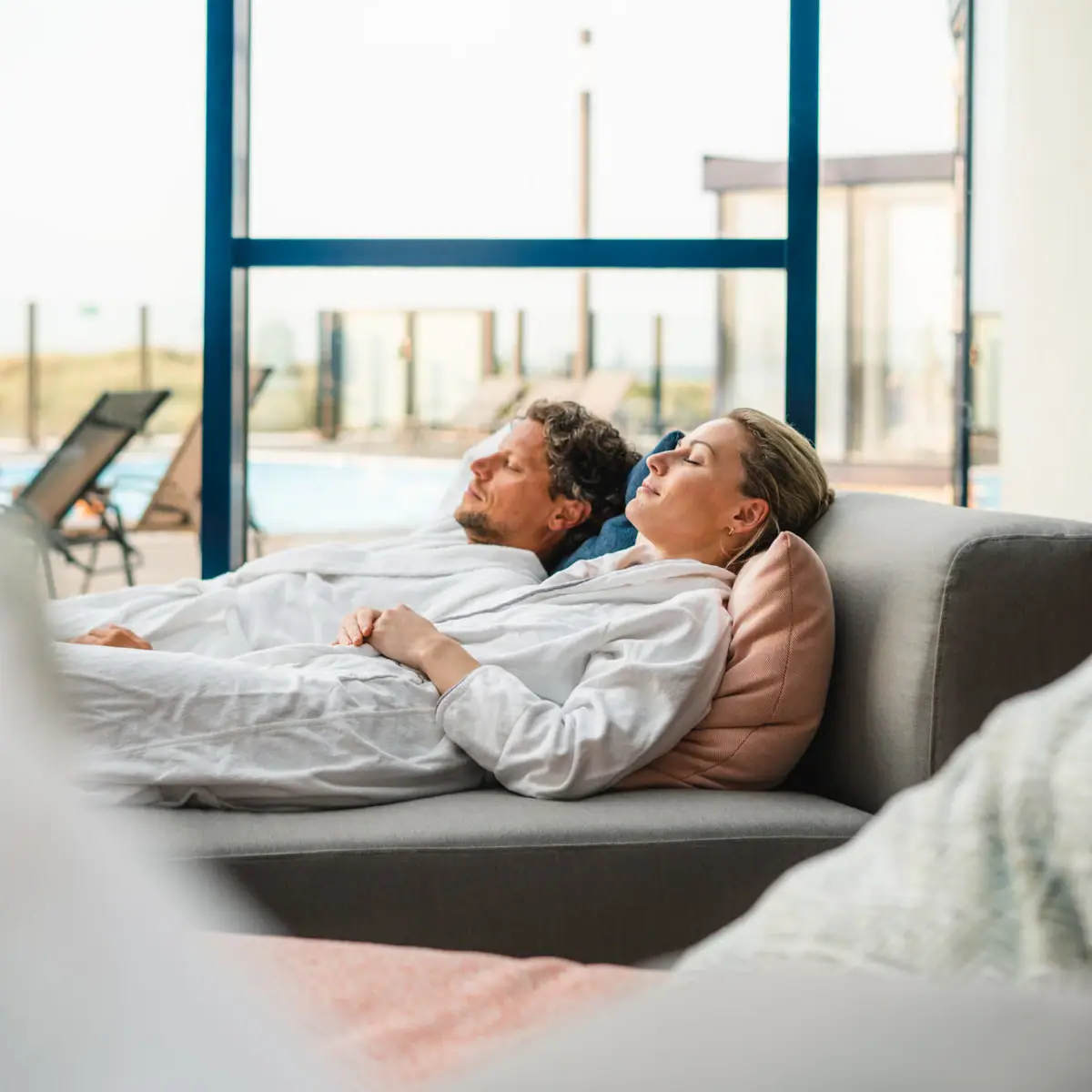 Ein Mann und eine Frau liegen entspannt auf einem Sofa.