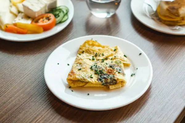 Omelette Ein Frühstückstisch mit Tellern voller Speisen und Getränken.