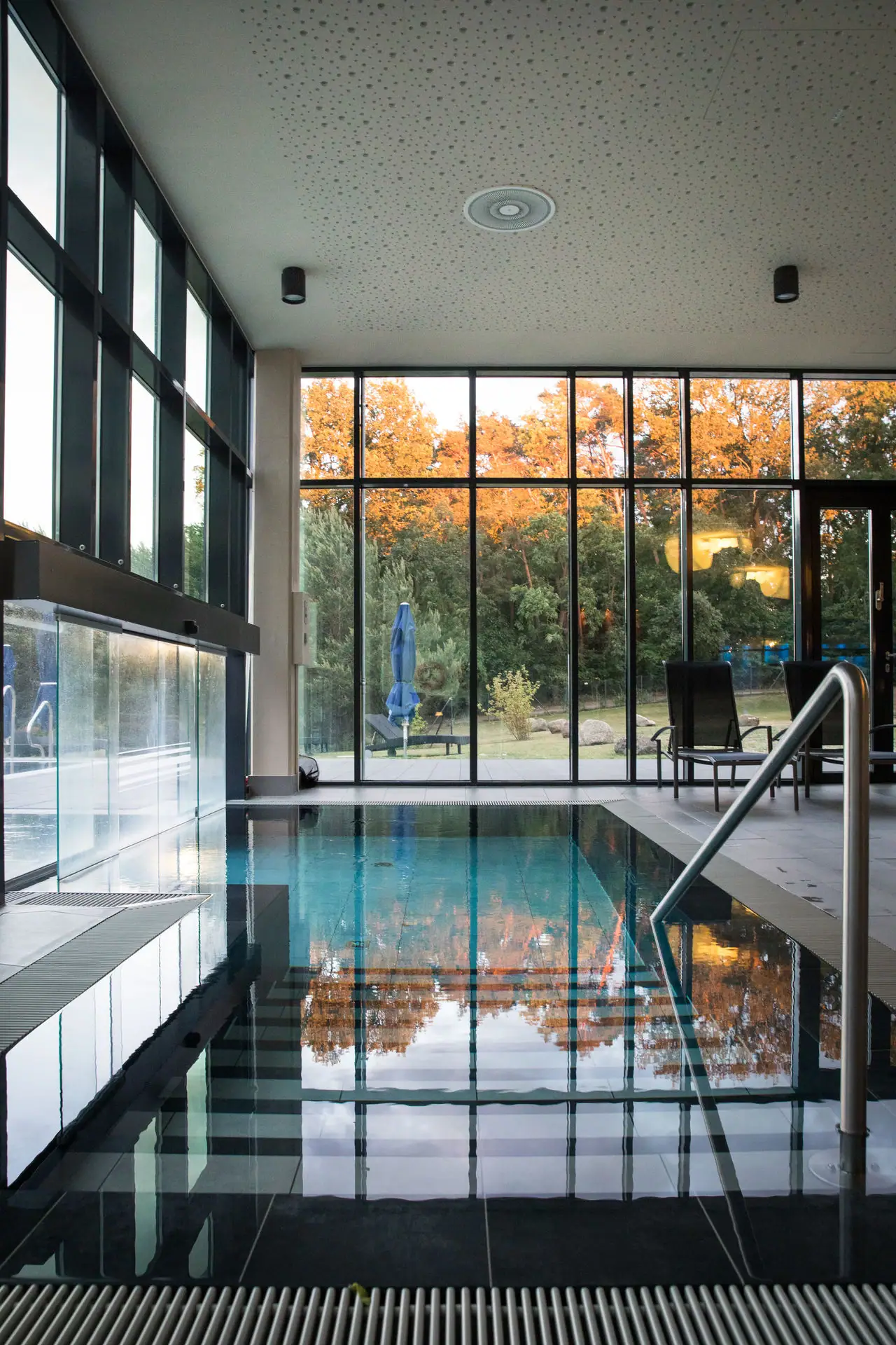 Der Zugang zum Außenpool mit großer Glaswand und großem Fenster.