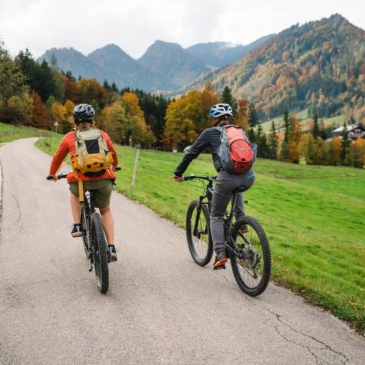 Zwei Personen fahren auf einer Straße in Ruhpolding Fahrrad.