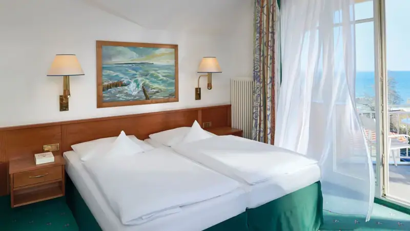 Ein Zimmer mit zwei Betten und einem Fenster.