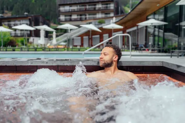 Ein Mann in einem Whirlpool im Freien.