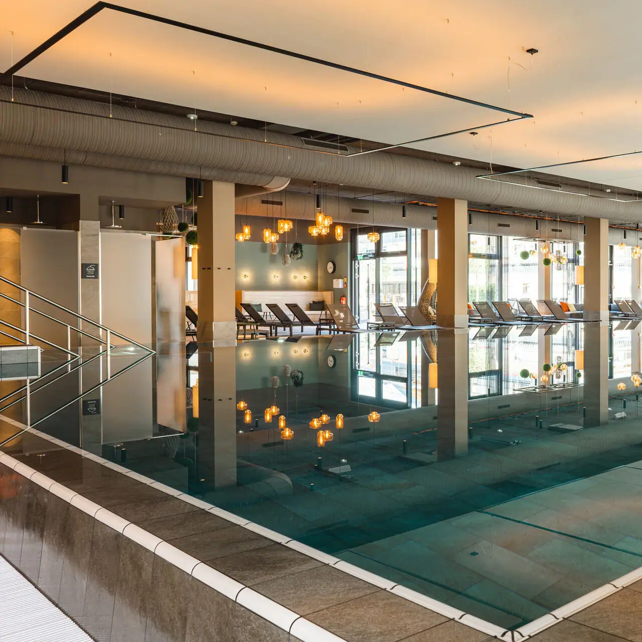 Ein großes Hallenbad mit Stühlen und einer Person, die in der Mitte steht.