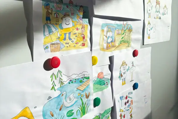 Illustration von Ajon Eine Gruppe von Kinderzeichnungen auf einem Whiteboard.