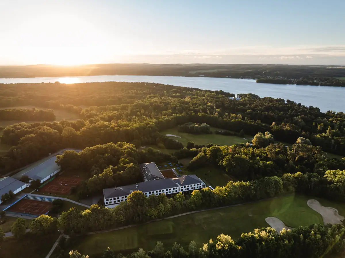 aja Bad Saarow Großer Gewässerbereich mit einem Gebäude und Bäumen im Vordergrund.