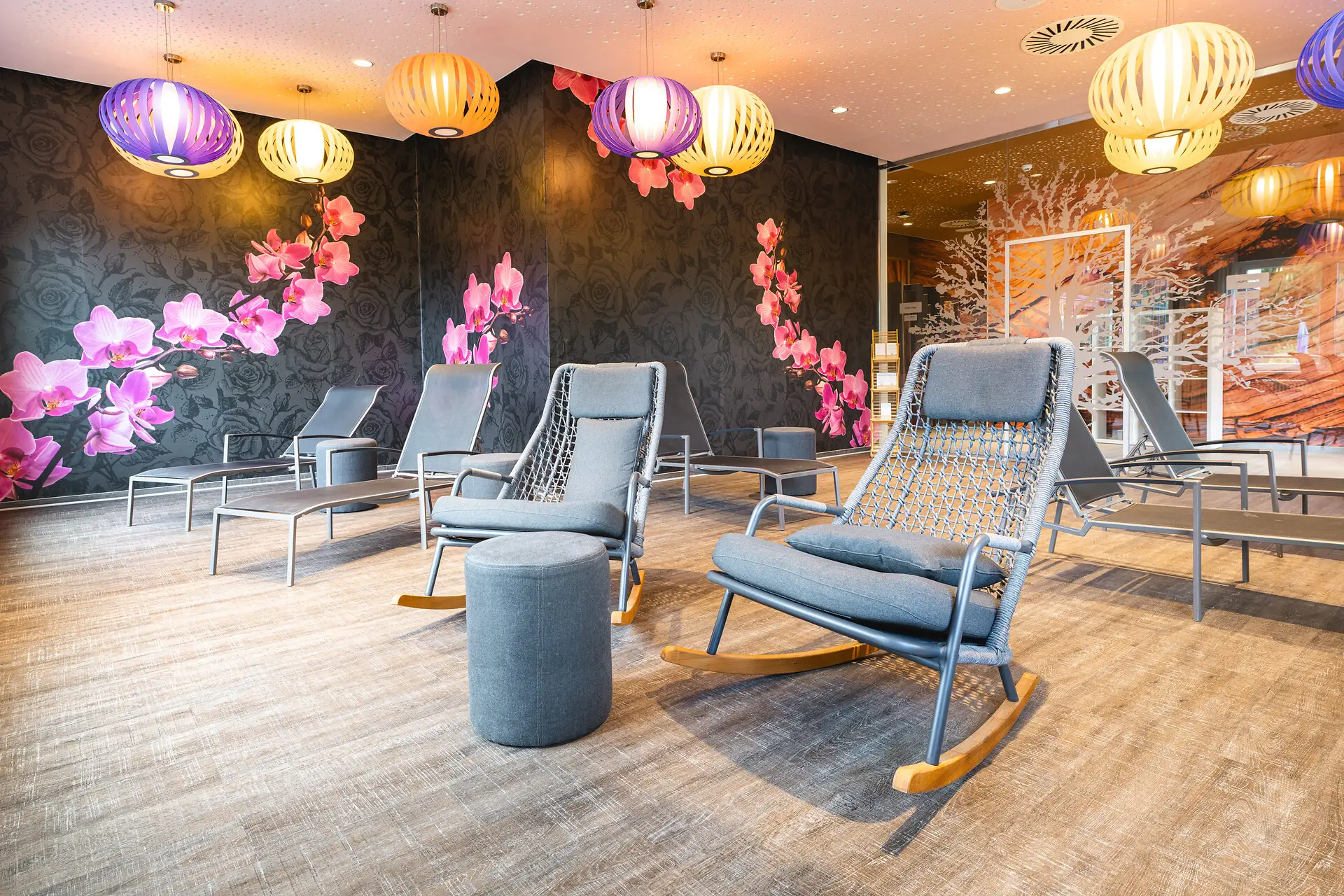 Ein Raum mit Stühlen und einer Wand mit Blumen.
