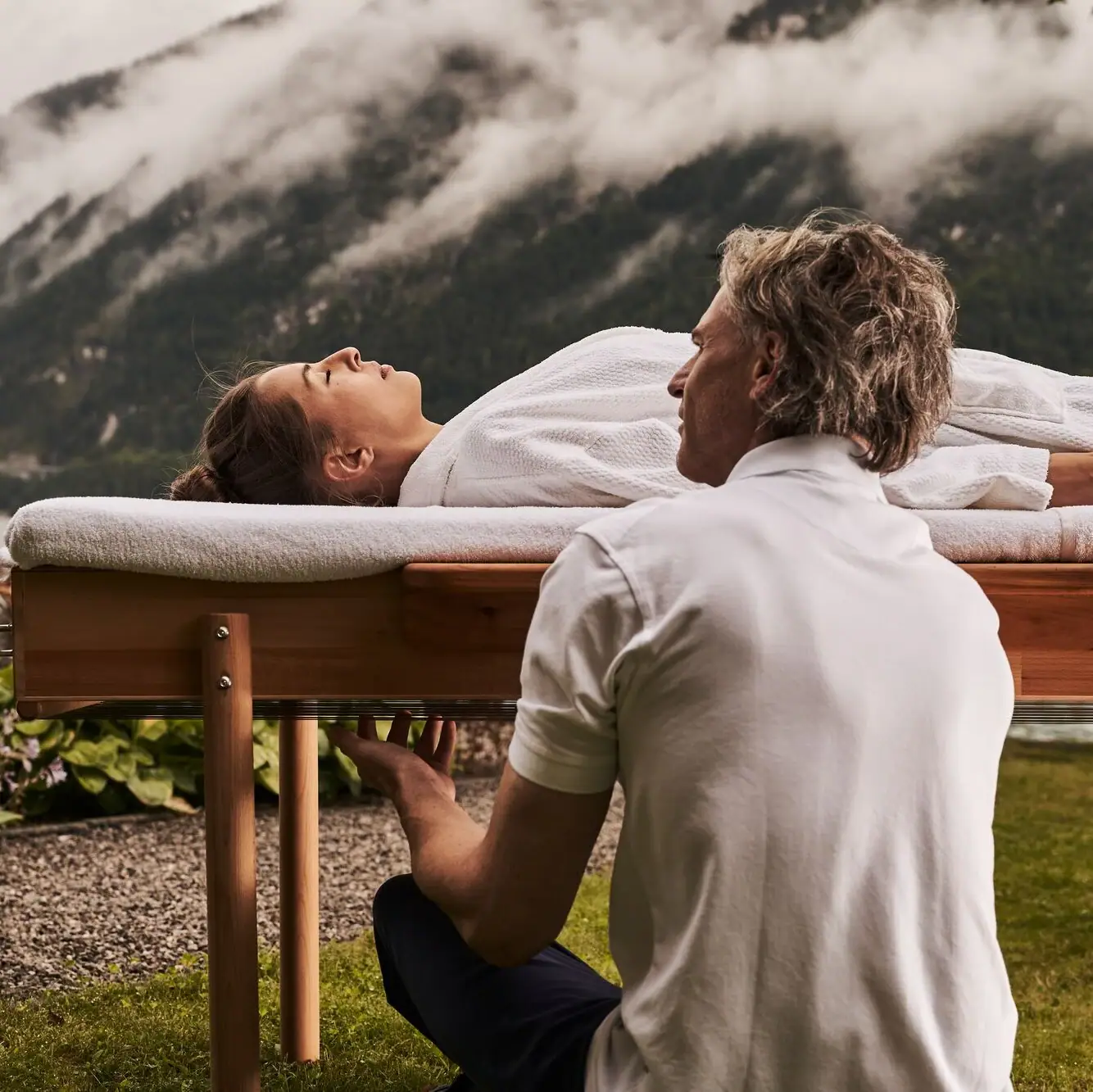 Ein Mann kniet vor einem Tisch, auf dem eine Frau liegt.