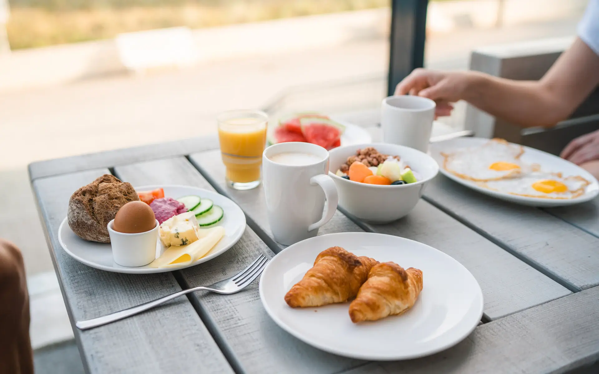 Table laden with a variety of dishes including breakfast items, snacks, and drinks.