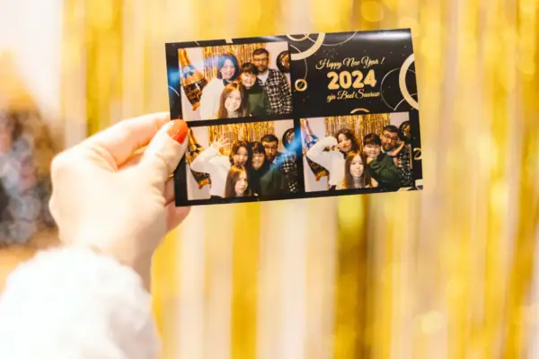 Silvesterparty im aja Bad Saarow Hand hält eine Karte mit einer Gruppe von Menschen. Die Karte ist mit Fotos vom Abend gefüllt.