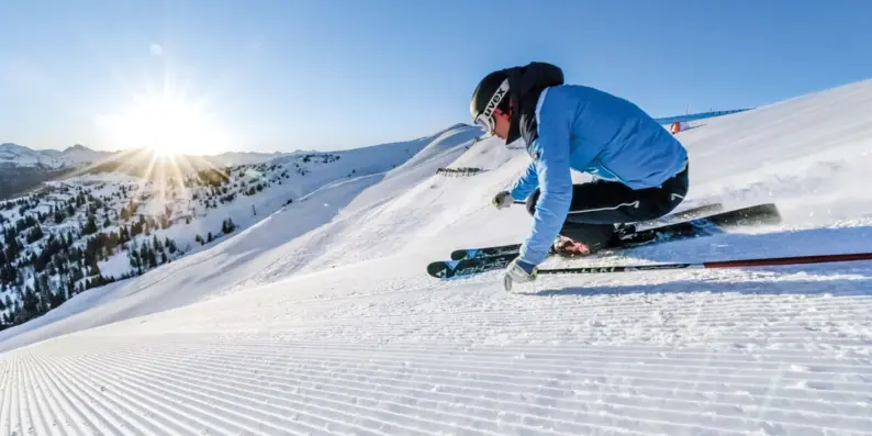 Person beim Skifahren auf einer verschneiten Piste.