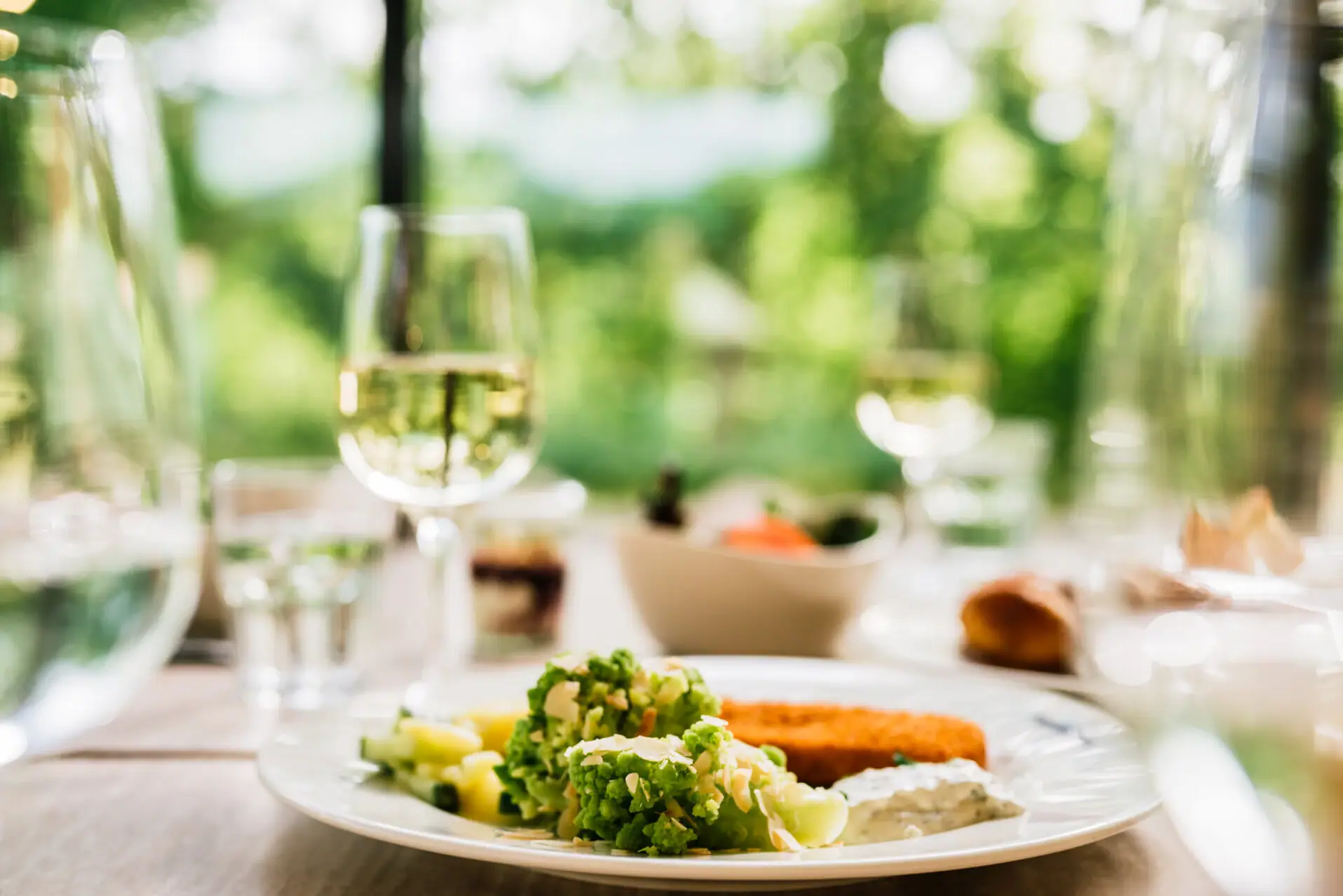 Fisch und Fleisch Ein Teller mit Essen und ein Glas Wein.