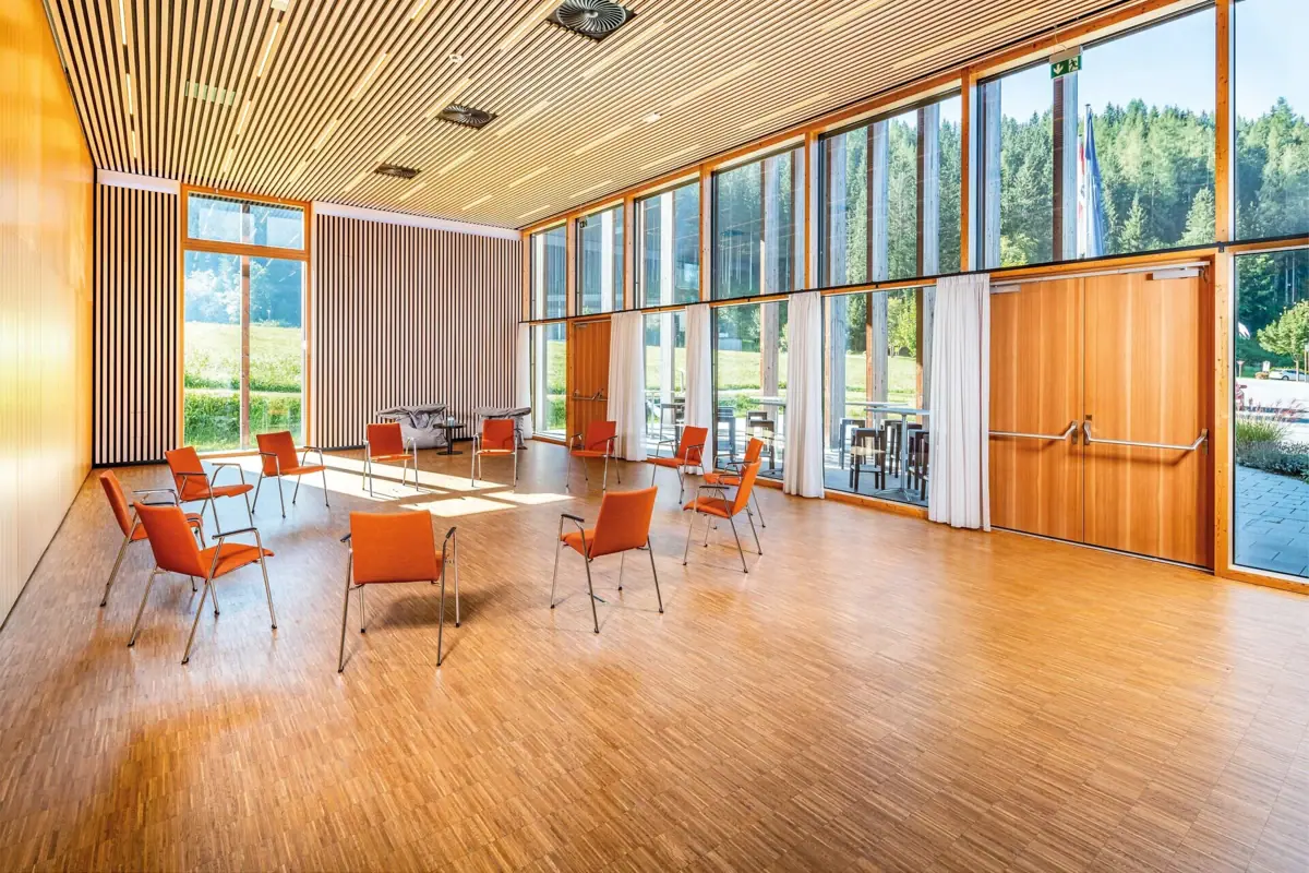 Tagungszentrum Werfenweng mit Tischen und Stühlen und großen Fenstern.