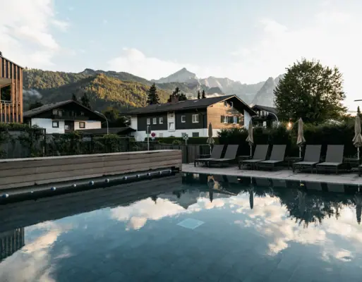 Pool mit Stühlen und Gebäude im Hintergrund