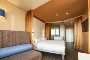 Zimmer im aja Warnemünde Ein Zimmer mit einem Bett und einem Sofa.