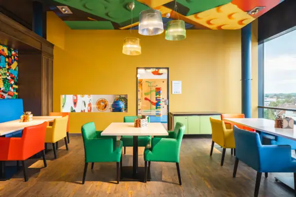 Ein Raum mit bunten Stühlen und Tischen.
