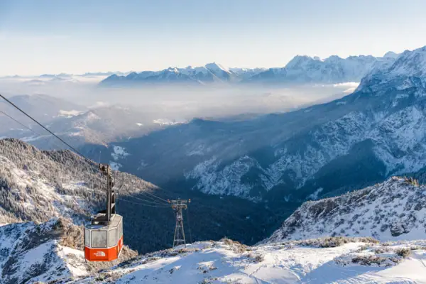 Seilbahn auf einem verschneiten Bergmassiv im Freien.