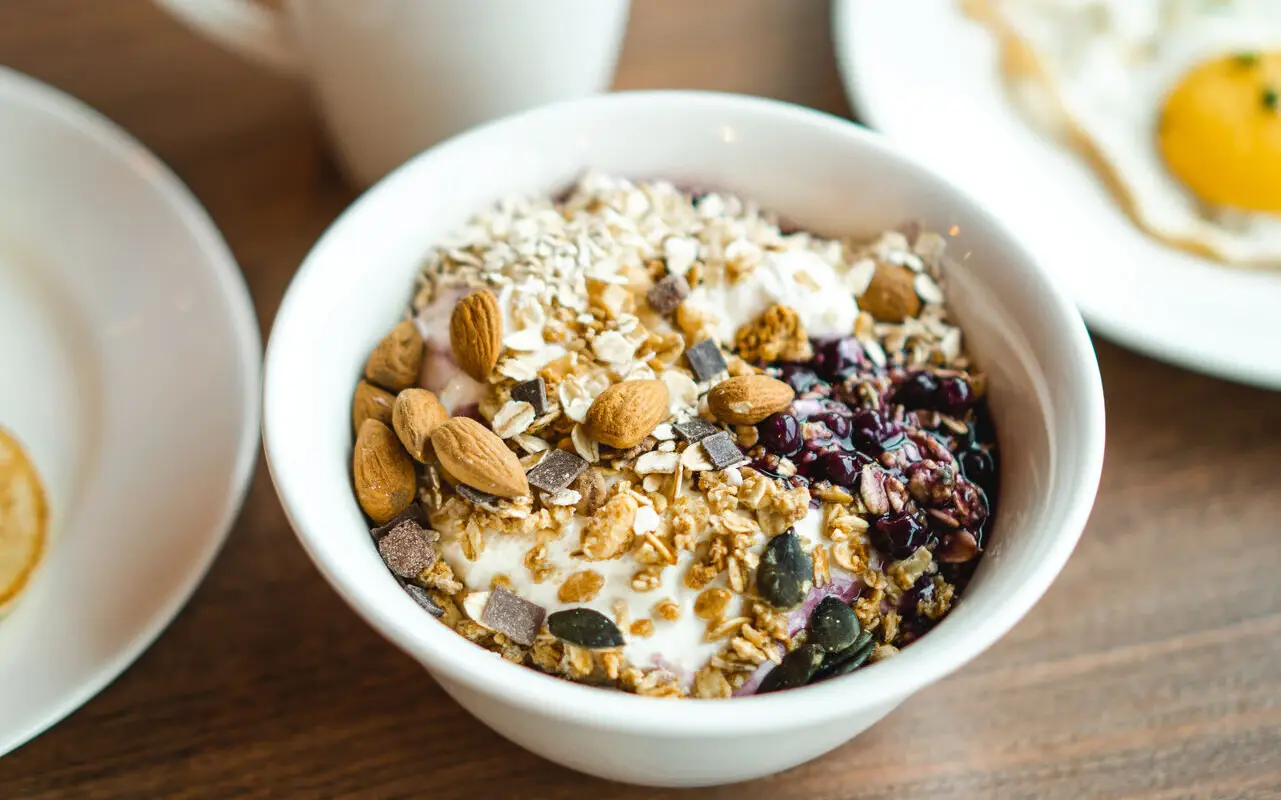 Eine Schüssel mit Joghurt und Granola auf einem Tisch.