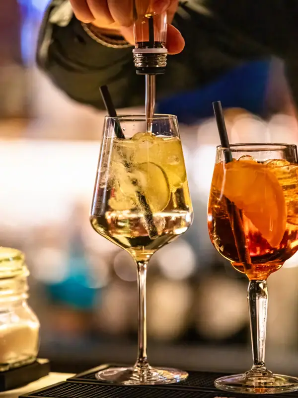 Eine Person gießt ein Getränk in ein Glas.