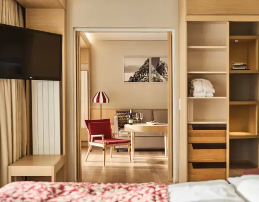 Ein Hotelzimmer mit einem Fernseher und einer Sitzecke mit einem Sofa und einem Stuhl.