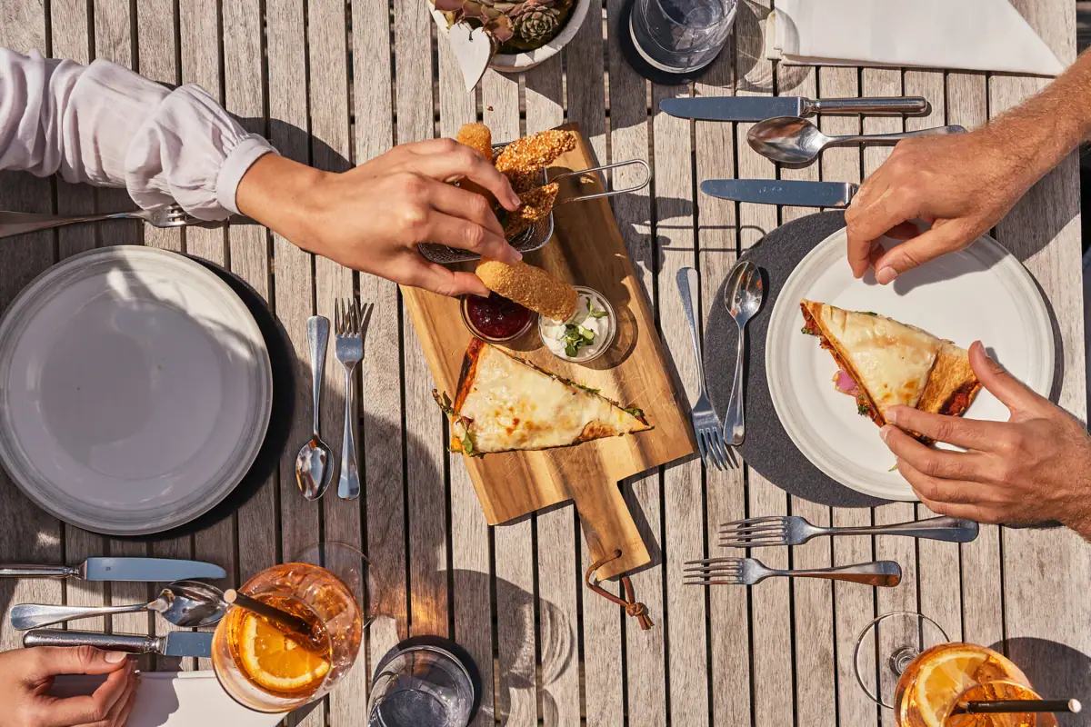 Eine Person isst Fast Food an einem Tisch.