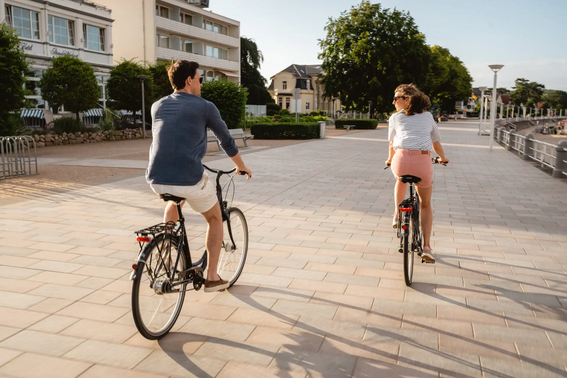 Fahrradtour Ein Mann und eine Frau fahren Fahrräder auf einem gepflasterten Weg.
