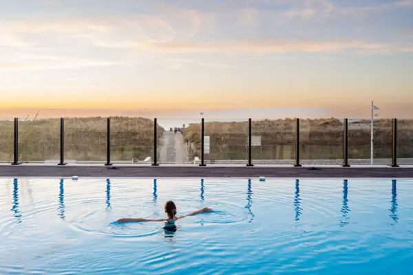 Eine Frau schwimmt im Außenpool des aja Warnemünde.