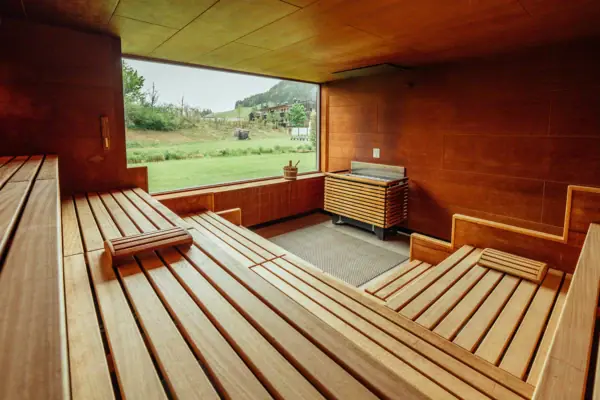 Sauna Ein Raum mit einer Holzbank und einem Grill.