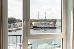 Doppelzimmer Blick aus einem Fenster auf ein Schiff im Hafen.