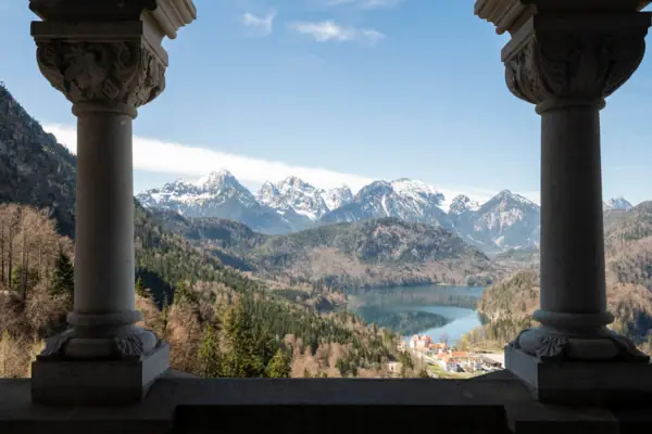 Blick auf einen See und Berge durch zwei Säulen.