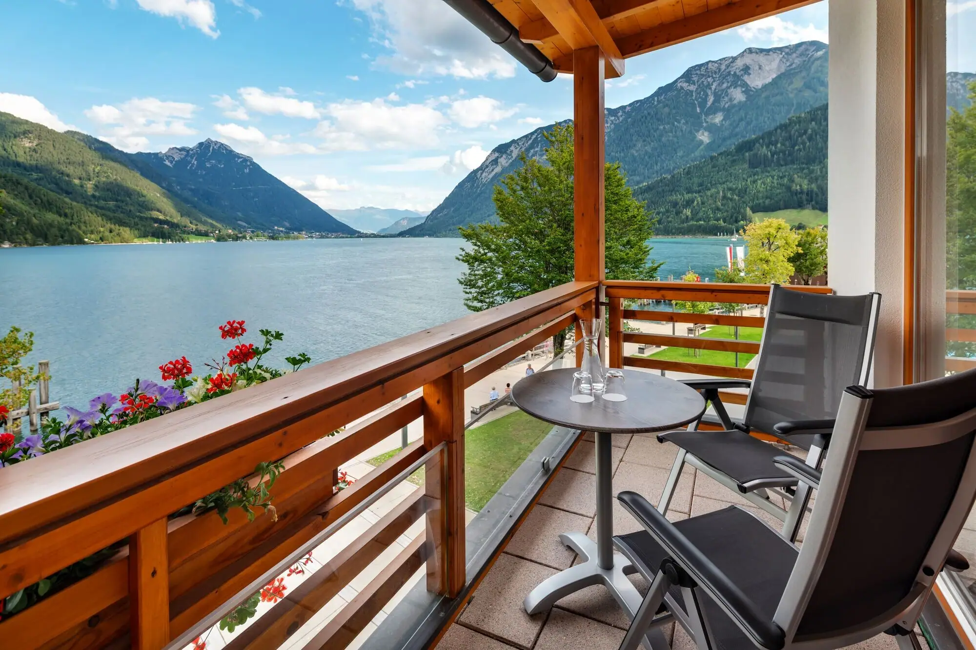 Suite mit Seeblick Balkon mit Tisch und Stühlen mit Blick auf einen See