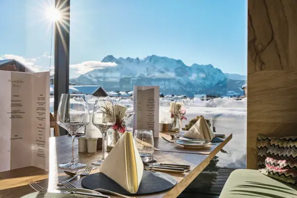 Ein Tisch mit Gläsern und Servietten, im Hintergrund ein Berg.