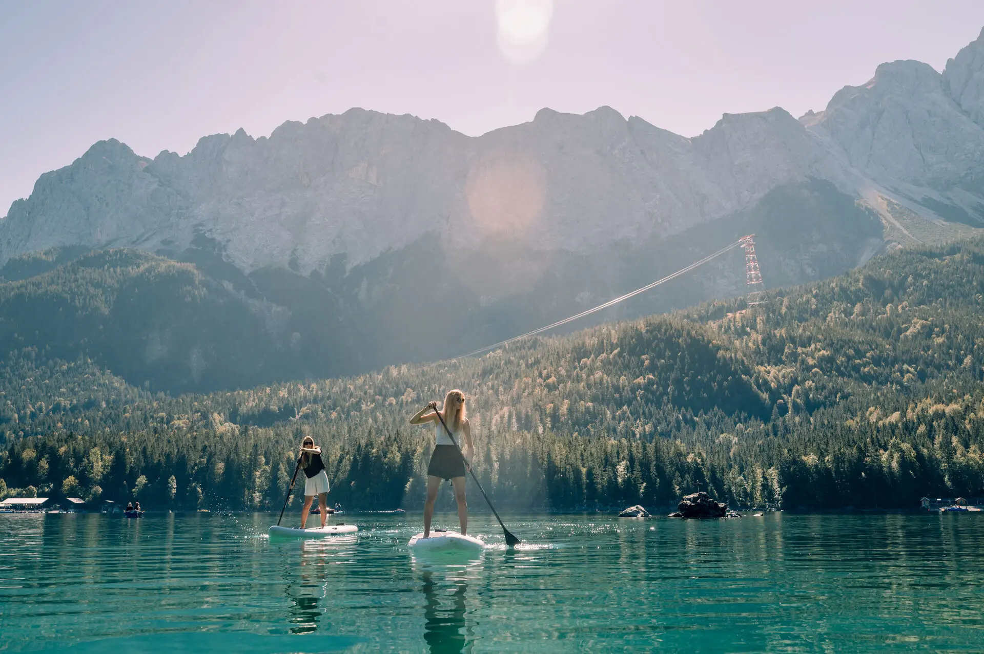 Zwei menschen fahren auf dem Eibsee mit einem stand up paddle board