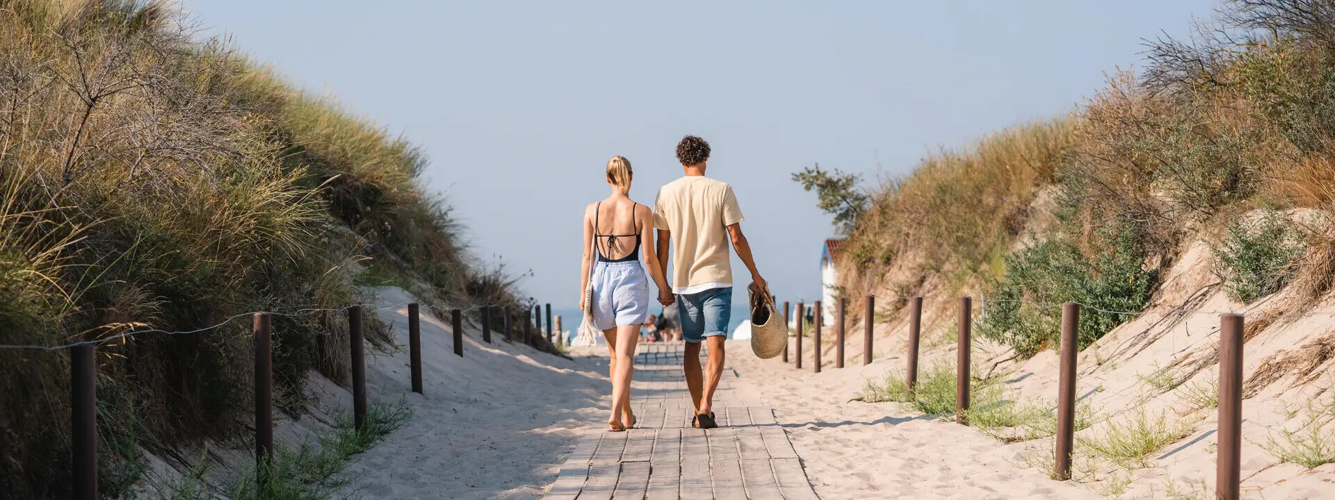 Strandaufgang Warnemünde Ein Mann und eine Frau gehen einen Weg entlang.