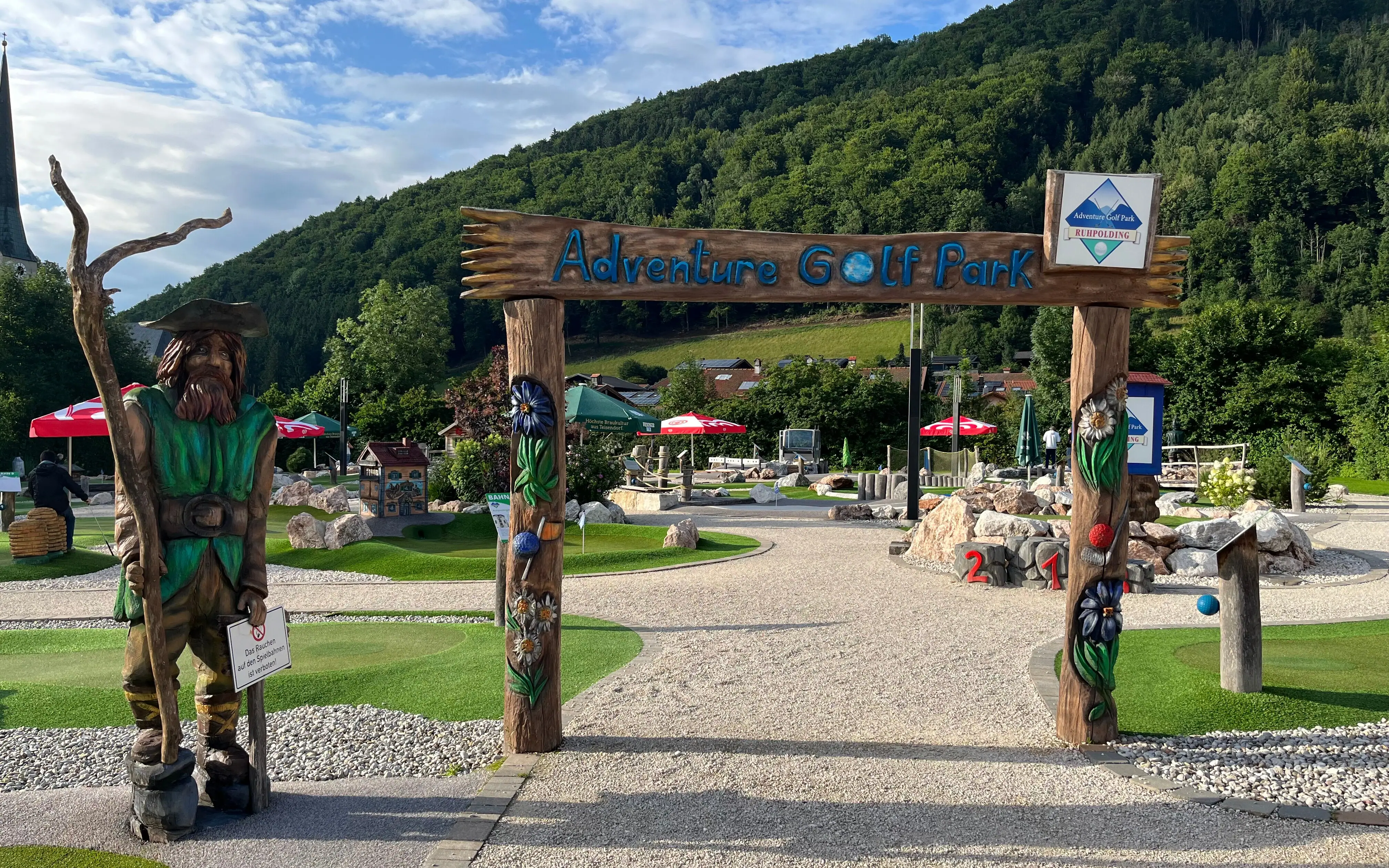 Adventure Golf Park Ruhpolding Ein Schild mit einer Statue darauf.